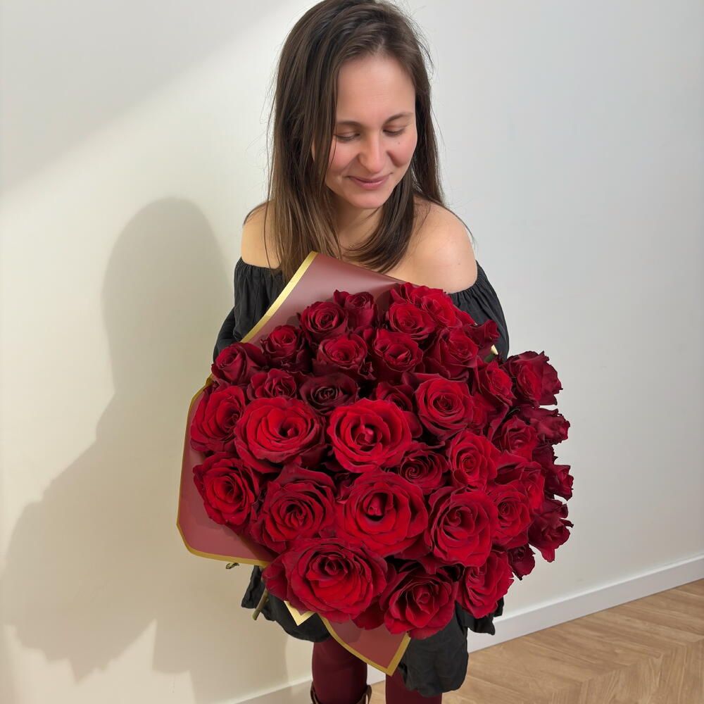 La florista de My Agosto con un ramo de 31 rosas rojas recién montado